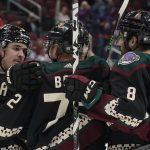 Arizona Coyotes' Clayton Keller (9) left, celebrates with Travis Boyd (72) and Nick Schmaltz (8) right, after Boyd's goal against the Montreal Canadiens during the first period of an NHL hockey game Monday, Jan. 17, 2022, in Glendale, Ariz. (AP Photo/Darryl Webb)