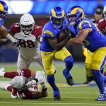 Los Angeles Rams running back Cam Akers, foreground, runs against the Arizona Cardinals during the first half of an NFL wild-card playoff football game in Inglewood, Calif., Monday, Jan. 17, 2022. (AP Photo/Marcio Jose Sanchez)