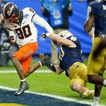 Oklahoma State wide receiver Brennan Presley (80) fumbles the football at the goal line as Notre Dame linebacker Drew White (40) defends during the second half of the Fiesta Bowl NCAA college football game, Saturday, Jan. 1, 2022, in Glendale, Ariz. (AP Photo/Ross D. Franklin)