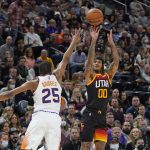 Utah Jazz guard Jordan Clarkson (00) shoots as Phoenix Suns forward Mikal Bridges (25) defends in the first half during an NBA basketball game Wednesday, Jan. 26, 2022, in Salt Lake City. (AP Photo/Rick Bowmer)