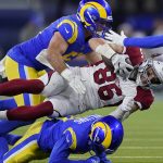 Arizona Cardinals tight end Zach Ertz (86) is tackled by Los Angeles Rams inside linebacker Troy Reeder, top, and cornerback Darious Williams during the second half of an NFL wild-card playoff football game in Inglewood, Calif., Monday, Jan. 17, 2022. (AP Photo/Marcio Jose Sanchez)