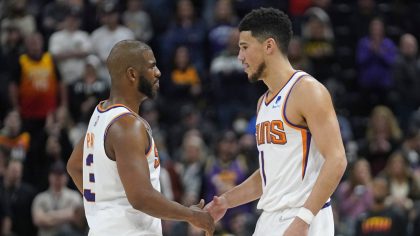 Phoenix Suns' Chris Paul, left, and Devin Booker (1) shake hands following their NBA basketball gam...