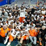 Oklahoma State players pose at mid field for a team photo after winning the Fiesta Bowl NCAA college football game against Notre Dame, Saturday, Jan. 1, 2022, in Glendale, Ariz. Oklahoma State won 37-35. (AP Photo/Ross D. Franklin)