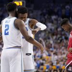 UCLA forward Cody Riley, left, and guard Peyton Watson, center, embrace while Arizona guard Adama Bal walks away as time runs out in an NCAA college basketball game Tuesday, Jan. 25, 2022, in Los Angeles. (AP Photo/Mark J. Terrill)