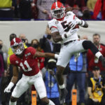 Georgia defensive back Kelee Ringo (5) intercepts a pass intended for Alabama wide receiver Traeshon Holden (11) and returns it for a touchdown late in the second half of the College Football Playoff championship game, Monday, Jan. 10, 2022, in Indianapolis. (Curtis Compton/Atlanta Journal-Constitution via AP)