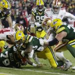 Green Bay Packers' A.J. Dillon (28) rruns for a touchdown during the firsrt half of an NFC divisional playoff NFL football game against the San Francisco 49ers Saturday, Jan. 22, 2022, in Green Bay, Wis. (AP Photo/Matt Ludtke)