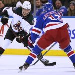 Arizona Coyotes defenseman Shayne Gostisbehere (14) skates against New York Rangers left wing Alexis Lafrenière (13) during the second period of an NHL hockey game, Saturday, Jan. 22, 2022, at Madison Square Garden in New York. (AP Photo/Mary Altaffer)