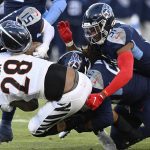 Cincinnati Bengals running back Joe Mixon (28) is hit by Tennessee Titans outside linebacker David Long Jr during the first half of an NFL divisional round playoff football game, Saturday, Jan. 22, 2022, in Nashville, Tenn. (AP Photo/Mark Zaleski)