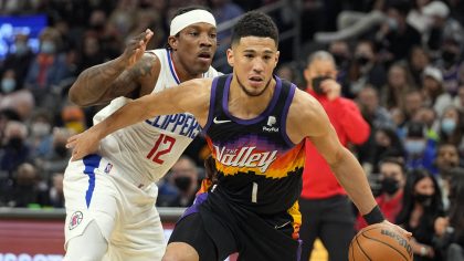 Phoenix Suns guard Devin Booker (1) drives past Los Angeles Clippers guard Eric Bledsoe during the ...