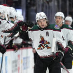 Arizona Coyotes right wing Clayton Keller celebrates a goal against the Colorado Avalanche with teammates on the bench during the first period of an NHL hockey game Friday, Jan. 14, 2022, in Denver. (AP Photo/Jack Dempsey)