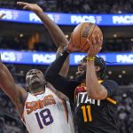 Phoenix Suns center Bismack Biyombo (18) defends as Utah Jazz guard Mike Conley (11) goes to the basket in the first half during an NBA basketball game Wednesday, Jan. 26, 2022, in Salt Lake City. (AP Photo/Rick Bowmer)