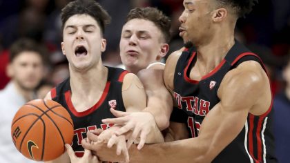 Arizona guard Pelle Larsson, center, is squeezed between Utah guards Lazar Stefanovic, left, and Ma...