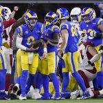 Los Angeles Rams quarterback Matthew Stafford, middle, is congratulated by teammates after scoring a touchdown against the Arizona Cardinals during the first half of an NFL wild-card playoff football game in Inglewood, Calif., Monday, Jan. 17, 2022. (AP Photo/Marcio Jose Sanchez)