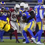 Los Angeles Rams running back Cam Akers, middle, is tackled by Arizona Cardinals defensive end J.J. Watt (99) during the second half of an NFL wild-card playoff football game in Inglewood, Calif., Monday, Jan. 17, 2022. (AP Photo/Marcio Jose Sanchez)