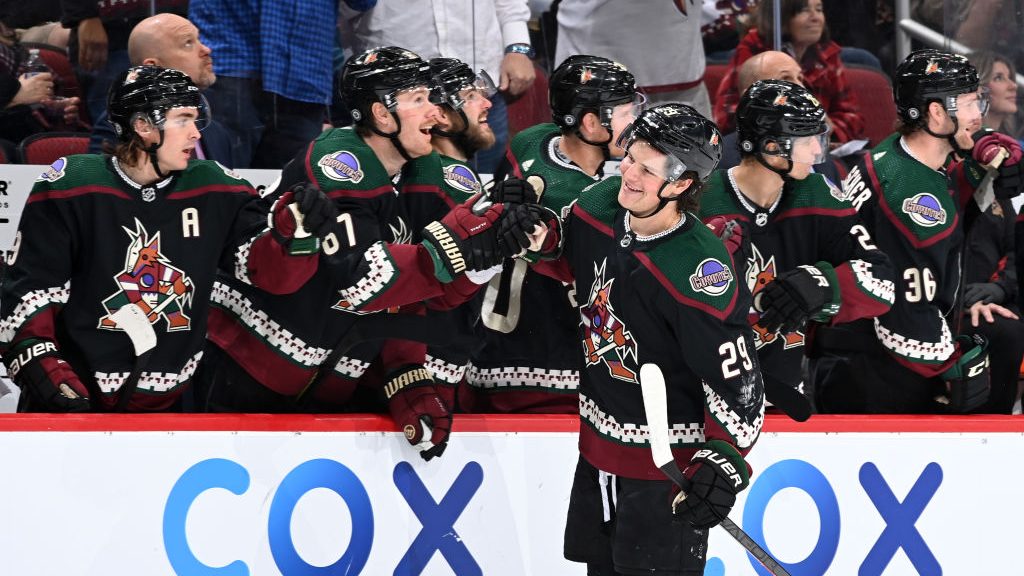 Barrett Hayton of the Arizona Coyotes celebrates with teammates on the bench after scoring a goal a...