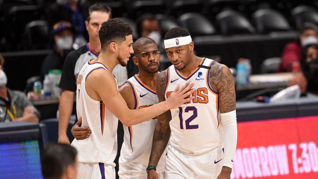 Devin Booker #1, Chris Paul #3, and Torrey Craig #12 of the Phoenix Suns take a moment later in the...