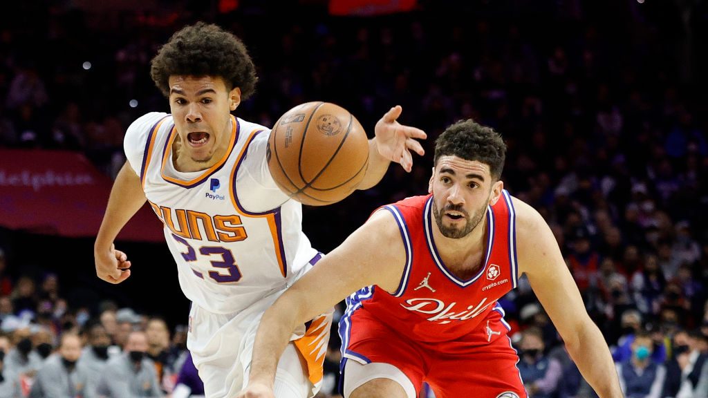 Cameron Johnson #23 of the Phoenix Suns and Georges Niang #20 of the Philadelphia 76ers chase a loo...