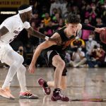 Southern California guard Drew Peterson (13) drives as Arizona State guard Marreon Jackson, let, defends during the first half of an NCAA college basketball game, Thursday, Feb. 3, 2022, in Phoenix. (AP Photo/Matt York)