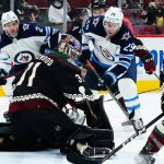 Arizona Coyotes goaltender Scott Wedgewood, front left, makes a save on a shot by Winnipeg Jets center Paul Stastny (25) as Coyotes defenseman Shayne Gostisbehere (14) and Jets defenseman Dylan DeMelo (2) look on during the second period of an NHL hockey game Sunday, Feb. 27, 2022, in Glendale, Ariz. (AP Photo/Ross D. Franklin)