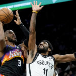 Phoenix Suns guard Chris Paul (3) drives as Brooklyn Nets guard Kyrie Irving (11) defends during the second half of an NBA basketball game, Tuesday, Feb. 1, 2022, in Phoenix. The Suns defeated the Nets 121-111. (AP Photo/Matt York)