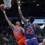 Oklahoma City Thunder guard Aaron Wiggins (21) shoots in front of Phoenix Suns center Deandre Ayton (22) in the first half of an NBA basketball game Thursday, Feb. 24, 2022, in Oklahoma City. (AP Photo/Sue Ogrocki)