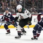 Arizona Coyotes left wing Lawson Crouse, center, knocks over Colorado Avalanche center Tyson Jost, right, as defenseman Samuel Girard pursues during the second period of an NHL hockey game Tuesday, Feb. 1, 2022, in Denver. Crouse was called for a penalty. (AP Photo/David Zalubowski)