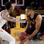 USC forward Isaiah Mobley, right, looks to pass under pressure from Arizona State guard Jeff Grace during the first half of an NCAA college basketball game, Thursday, Feb. 3, 2022, in Phoenix. (AP Photo/Matt York)