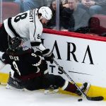 Los Angeles Kings defenseman Drew Doughty (8) collides with Arizona Coyotes right wing Clayton Keller (9) as they go for the puck during the first period of an NHL hockey game Saturday, Feb. 19, 2022, in Glendale, Ariz. (AP Photo/Ross D. Franklin)