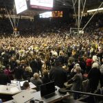 Fans rush the floor after Colorado's victory over Arizona in an NCAA college basketball game Saturday, Feb. 26 2022, in Boulder, Colo. (AP Photo/David Zalubowski)