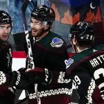 Arizona Coyotes center Nick Schmaltz, middle, smiles as he celebrates his goal against the Vegas Golden Knights with right wing Clayton Keller (9) and center Barrett Hayton (29) during the third period of an NHL hockey game Friday, Feb. 25, 2022, in Glendale, Ariz. The Coyotes won 3-1. (AP Photo/Ross D. Franklin)