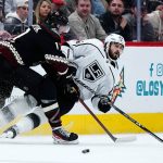 Arizona Coyotes center Alex Galchenyuk, left, sends Los Angeles Kings center Phillip Danault (24) to the ice during the second period of an NHL hockey game Saturday, Feb. 19, 2022, in Glendale, Ariz. (AP Photo/Ross D. Franklin)