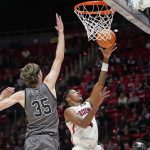 Arizona guard Dalen Terry (4) goes to the basket as Utah center Branden Carlson (35) defends during the first half of an NCAA college basketball game Thursday, Feb. 24, 2022, in Salt Lake City. (AP Photo/Rick Bowmer)