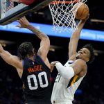 Utah Jazz center Hassan Whiteside (21) dunks over Phoenix Suns center JaVale McGee (00) during the first half of an NBA basketball game, Sunday, Feb. 27, 2022, in Phoenix. (AP Photo/Matt York)