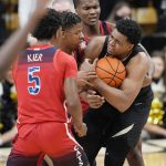 Colorado forward Evan Battey, right, battles for control of a loose ball with, from left front to back, Arizona guards Justin Kier, Dalen Terry and Bennedict Mathurin in the second half of an NCAA college basketball game Saturday, Feb. 26, 2022, in Boulder, Colo. (AP Photo/David Zalubowski)