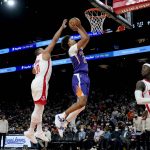 Phoenix Suns forward Cameron Johnson (23) shoots as Houston Rockets guard Eric Gordon (10) defends during the second half of an NBA basketball game Wednesday, Feb. 16, 2022, in Phoenix. The Suns won 124-121. (AP Photo/Matt York)