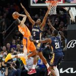 Phoenix Suns forward Mikal Bridges (25) shoots over New Orleans Pelicans forward Herbert Jones (5) during the first half of an NBA basketball game, Friday, Feb. 25, 2022, in Phoenix. (AP Photo/Matt York)
