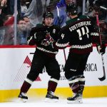 Arizona Coyotes right wing Clayton Keller (9) celebrates his goal against the Los Angeles Kings with defenseman Shayne Gostisbehere (14) during the second period of an NHL hockey game Saturday, Feb. 19, 2022, in Glendale, Ariz. (AP Photo/Ross D. Franklin)