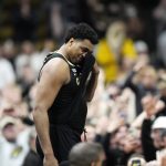 Colorado forward Evan Battey struggles to address fans after they rushed the floor after an NCAA college basketball game against Arizona, Saturday, Feb. 26, 2022, in Boulder, Colo. (AP Photo/David Zalubowski)