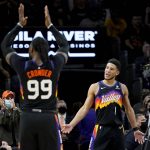 Phoenix Suns guard Devin Booker (1) and forward Jae Crowder (99) celebrate during the second half of an NBA basketball game against the Brooklyn Nets, Tuesday, Feb. 1, 2022, in Phoenix. The Suns defeated the Nets 121-111. (AP Photo/Matt York)
