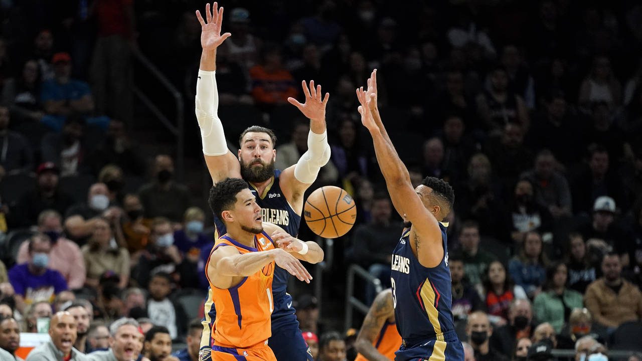 Phoenix Suns guard Devin Booker (1) is pressured by New Orleans Pelicans center Jonas Valanciunas a...