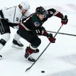 Arizona Coyotes defenseman Dysin Mayo (61) skates with the puck in front of Los Angeles Kings center Adrian Kempe (9) during the first period of an NHL hockey game Wednesday, Feb. 23, 2022, in Glendale, Ariz. (AP Photo/Ross D. Franklin)