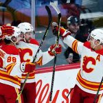 Calgary Flames center Blake Coleman (20) celebrates his goal against the Arizona Coyotes with left wing Andrew Mangiapane (88) and center Mikael Backlund, right, during the first period of an NHL hockey game Wednesday, Feb. 2, 2022, in Glendale, Ariz. (AP Photo/Ross D. Franklin)