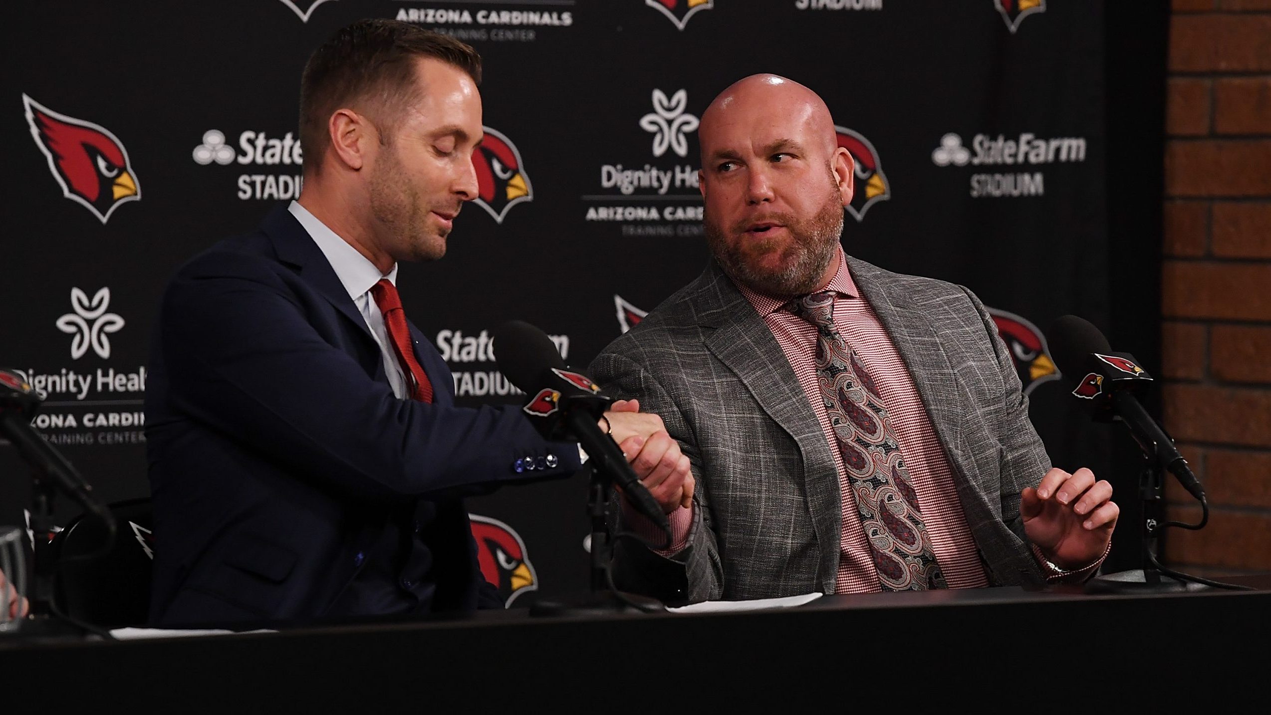 Arizona Cardinals new head coach Kliff Kingsbury shakes hands with general manager Steve Keim (R) a...