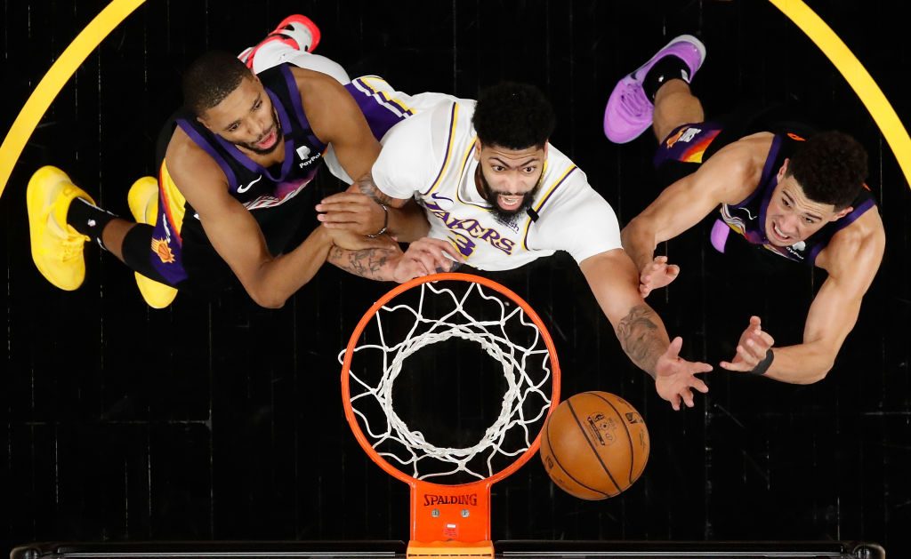 Anthony Davis #3 of the Los Angeles Lakers reaches for a rebound over Mikal Bridges #25 and Devin B...