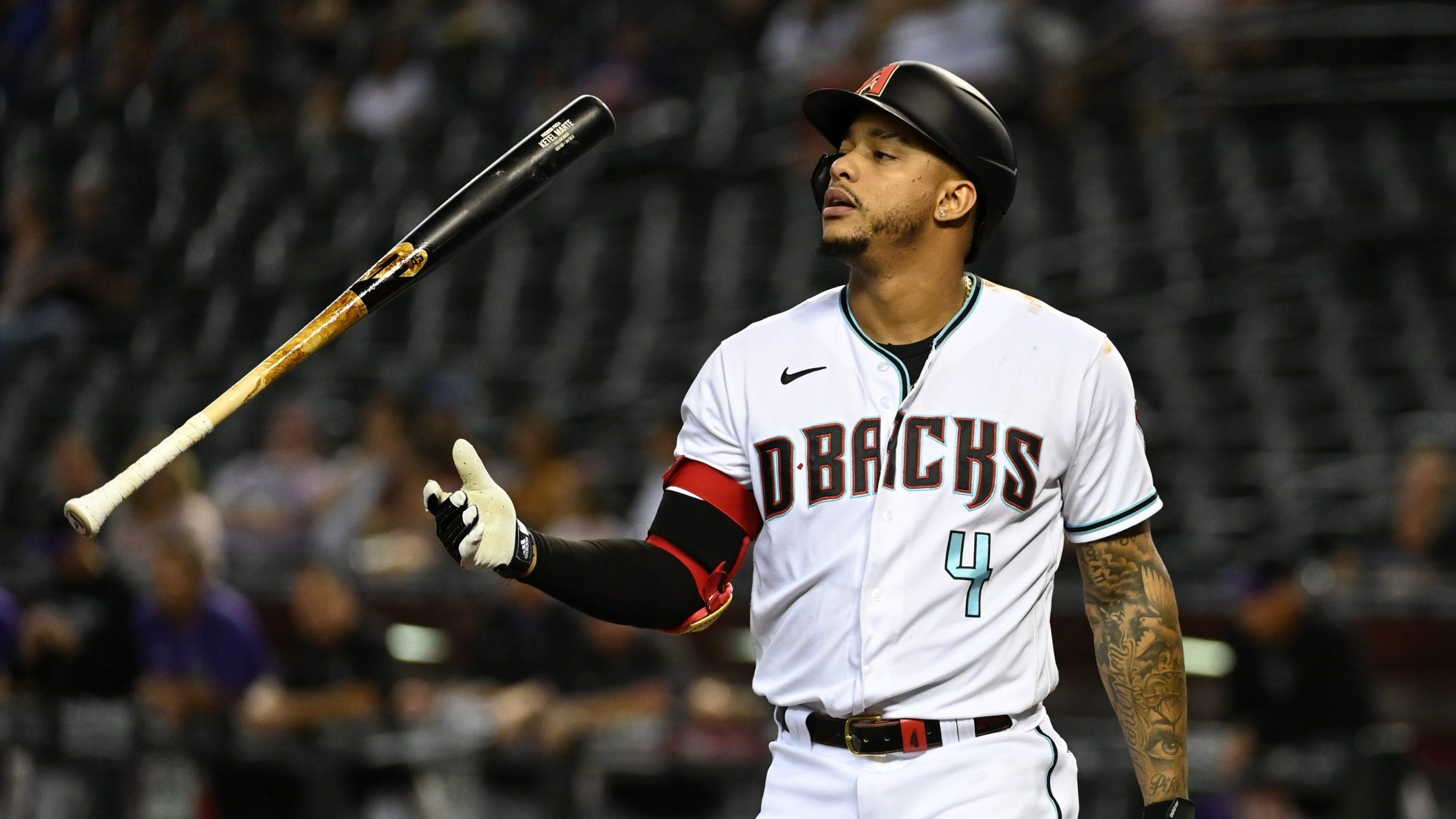 Ketel Marte #4 of the Arizona Diamondbacks tosses his bat after being called out on strikes against...