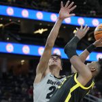 Colorado's Tristan da Silva (23) guards Oregon's Quincy Guerrier (13) during the first half of an NCAA college basketball game in the quarterfinal round of the Pac-12 tournament Thursday, March 10, 2022, in Las Vegas. (AP Photo/John Locher)
