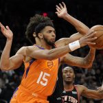 Phoenix Suns guard Cameron Payne (15) dishes off against the New York Knicks during the second half of an NBA basketball game, Friday, March 4, 2022, in Phoenix. The Phoenix Suns defeated the Knicks 115-114. (AP Photo/Matt York)