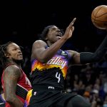 Phoenix Suns guard Aaron Holiday (4) shoots against the Portland Trail Blazers during the second half of an NBA basketball game, Wednesday, March 2, 2022, in Phoenix. (AP Photo/Matt York)