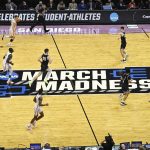 Arizona and Wright State players move past the March Madness logo during the first half of a first-round NCAA college basketball tournament game, Friday, March 18, 2022, at Viejas Arena in San Diego. (AP Photo/Denis Poroy)