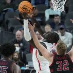 Arizona's Oumar Ballo (11) grabs a rebound over Stanford's Lukas Kisunas (32) during the first half of an NCAA college basketball game in the quarterfinal round of the Pac-12 tournament Thursday, March 10, 2022, in Las Vegas. (AP Photo/John Locher)